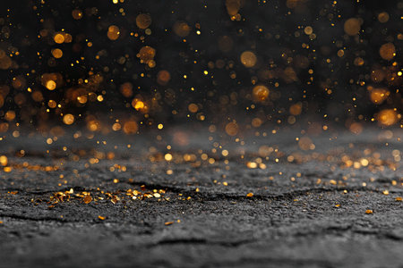 Scattered golden confetti on dark surfaceの素材
