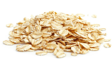 oat flakes isolated on a white background, emphasizing the versatility of this breakfast ingredient for oatmeal and granola.の素材