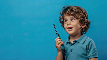 A boy with a professional walkie-talkie, communicating on a blue background. Fuel imaginative play with our kid-friendly gadgets. #AdventurePlay"の素材