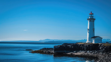 Illuminate the horizon with the timeless beacon of a lighthouse amidst a tranquil sea under a vast blue sky. Solace, safety, and maritime allureの素材