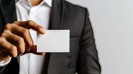 A sophisticated man in a suit delicately presents a business card, exuding charm and professionalism.の素材