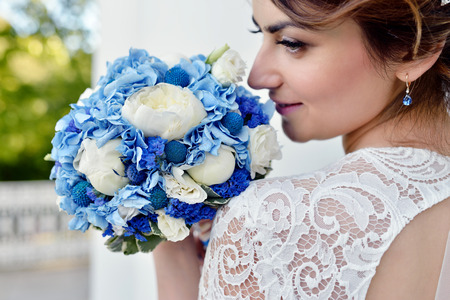 Beauty bride in bridal gown with bouquet and lace veilの写真素材