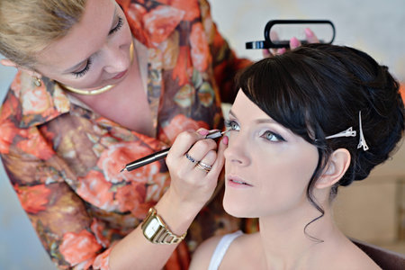 Wedding makeup artist making a make up for bride. Beautiful sexy model girl indoors. Beauty woman...
