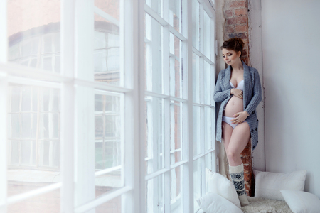 Beauty pregnant woman indoors. Female portrait of cute lady. Close-up beautiful model girl in elegant poseの写真素材