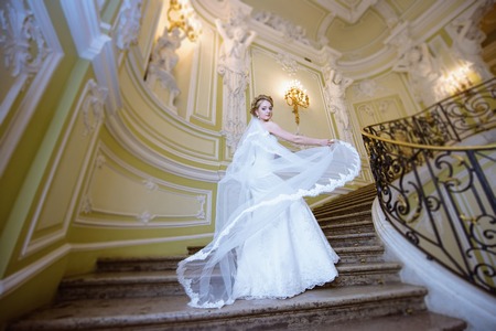 Beauty bride in bridal gown with lace veil indoorsの写真素材