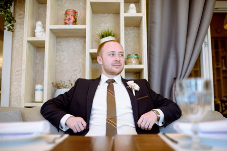 Handsome groom in suit in the hall