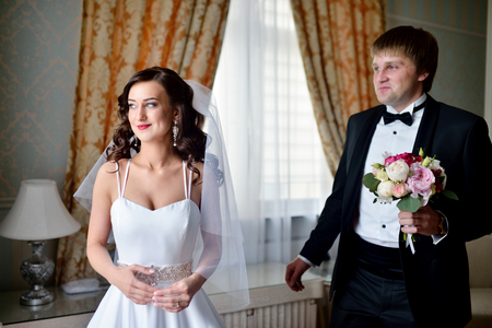 Handsome groom is seeing first the beauty bride in the morningの写真素材