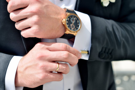 Groom is wearing cuff-links indoors