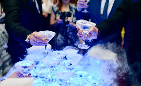 Beautiful wedding couple is pouring champagne indoorsの写真素材