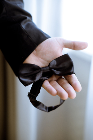 Groom is wearing a bowtie indoorsの写真素材