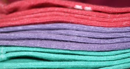 A close-up photograph of a pile of three pairs of socksの写真素材