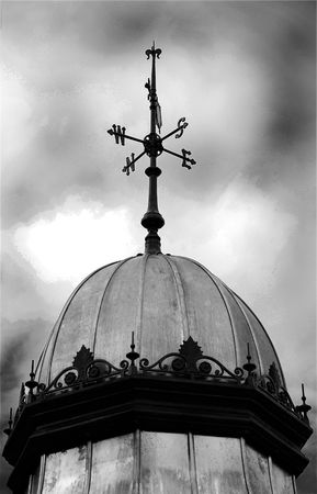 A photograph of the points of the compass on a weather vane, in black and white under a moody skyの写真素材
