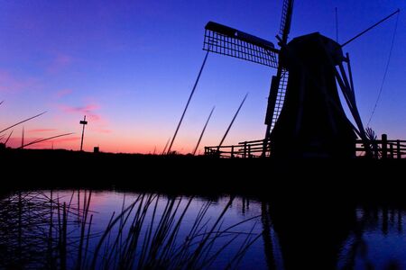 Dutch wind mill at a beautiful colorful sunsetの写真素材