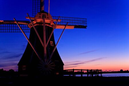 Dutch wind mill at a beautiful colorful sunsetの写真素材
