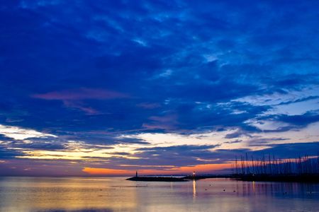 Harbour in a calm lake with boats at sunsetの写真素材