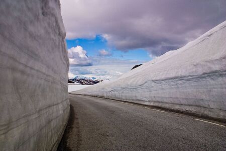 Mountain road with high snow wall in Norwayの写真素材