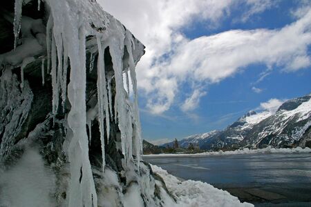 A mountain rock covered with ice and blue skyの写真素材