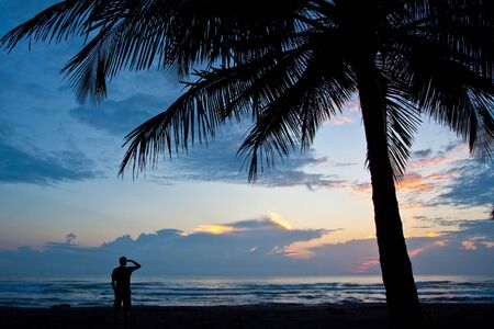 Beautiful sunset on the beach with palm treeの写真素材