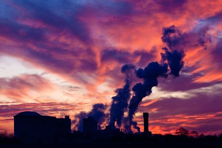 Industrial factory with smoking chimney at sunsetの写真素材