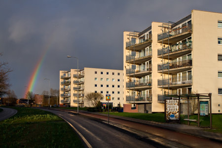 Rainbow in the city with sun on the apartment blocksの写真素材