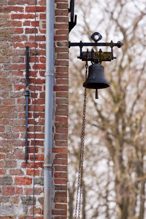 Detail of an ancient brick wall with bellの写真素材