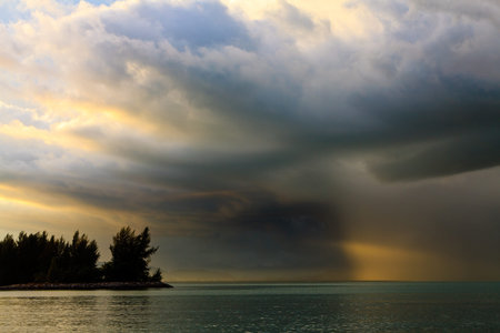 Thunder storm with rain lit by the sun at a lake