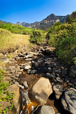 Riverbed with mountains in the background on a sunny dayの写真素材