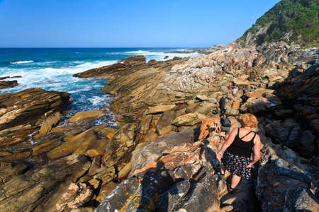 Women hiking along the Rocky dangerous coastlineの写真素材