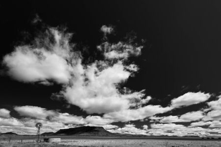 Windmill in a desolate landscape with beautiful cloudscape in Africaの写真素材