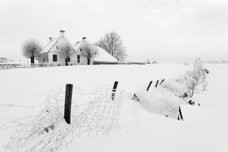 House in a cold white winter landscapeの写真素材