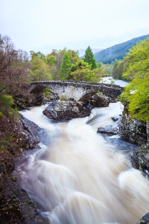 River and bridge in a mountain landscape in scotolandの写真素材