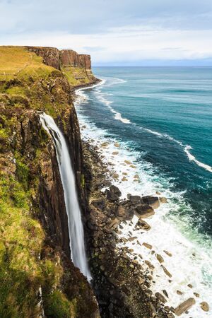 Steep rocky coastline with water fall in Scotlandの写真素材
