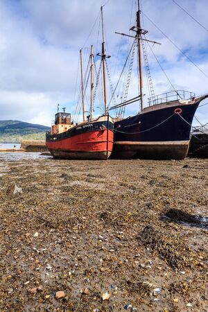 Boats lying in the mud in the harbourの写真素材