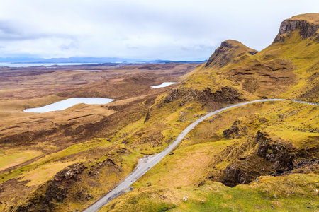 Road through the mountains with the sea in the background in Scotland