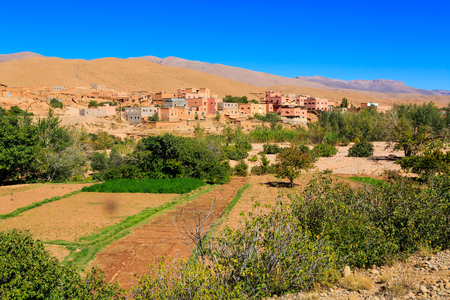 Landscape of a typical moroccan berber village made of red stone with oasis in the valleyの写真素材
