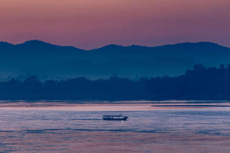Fishing boat on the Mekong river at sunset, Laos.の写真素材