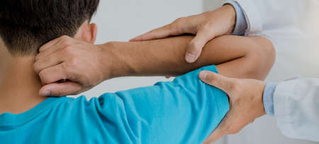 Physiotherapist consulting with patient about elbow pain problems.Physical therapy conceptの写真素材