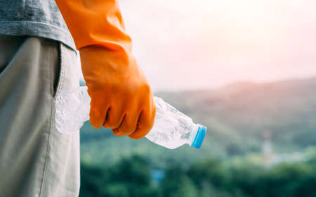 Volunteer man collecting trash.Garbage bottles picked up. Plastic and food waste concept. Clean planet Earth, collect garbage, save environment,save earth.の写真素材