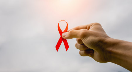 WORLD AIDS DAY concept.closeup of a young man with a red awareness ribbon.