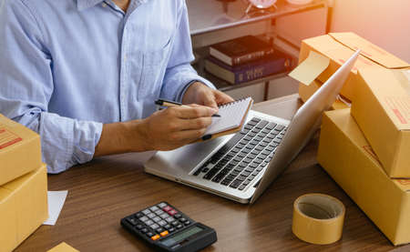 Man online seller check customer address with notebook for deliver to customer. Online selling,e-commerce.の写真素材