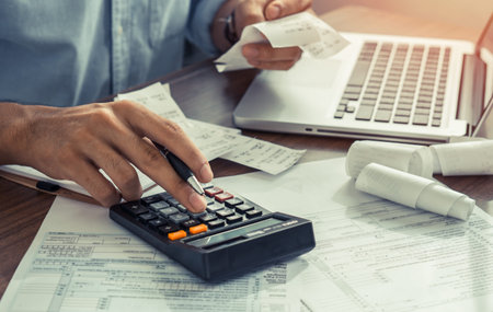 The office man calculate bills with using calculator in home office. financial concept.