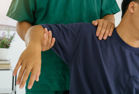 doctor or physiotherapist stretching a mature mans arm in the hospital.