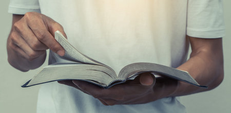 Young man are holding an open Bible.Sunday readings, Bibleの写真素材