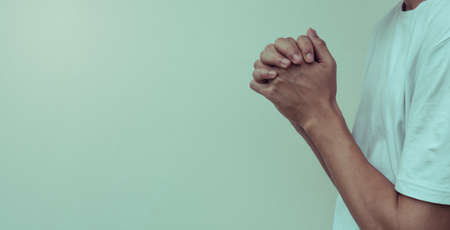 Hands folded in prayer at home.concept for faith, spirituality and religion, man praying in the morning.の写真素材