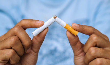 Cigarette.World No Tobacco Day Concept.Stop smoking cigarettes concept. Closeup woman holding broken...