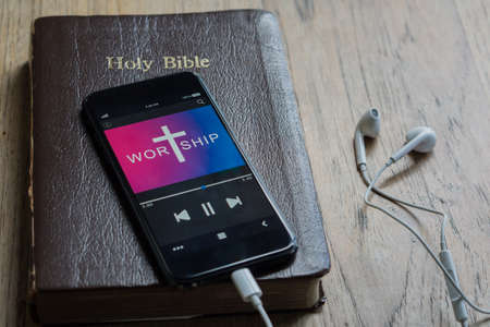 Bible with phone and headphones,Concept listen the words of God.Bible, phone and earphones on wood table.の写真素材