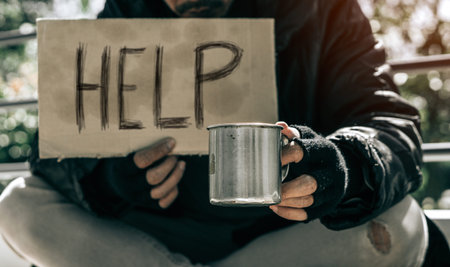 Beggar,Homeless adult man sitting on the street to get help. Indifference of people. Social...