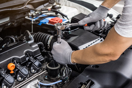 Mechanic man working on the engine of the car in the garage.Car service and maintenance,Repair...