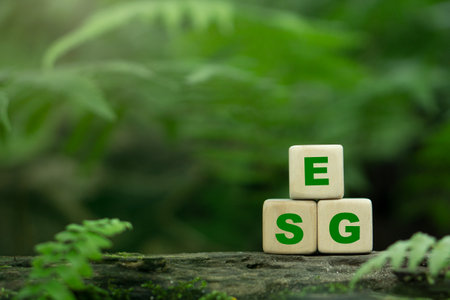 ESG concept ESG icon on a woodblock for environmental, social, and governance in sustainable and ethical business on the Network connection on a green background.の写真素材