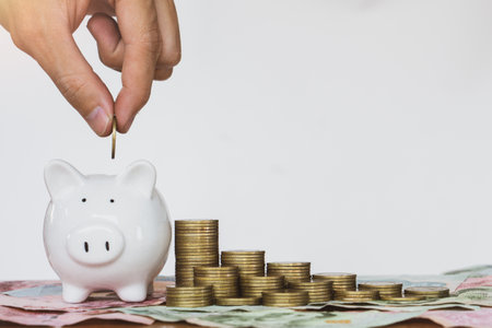 Man hand putting coin into piggy for saving money wealth and financial accounting concept.money saving goal for rainy day.copy space.の写真素材